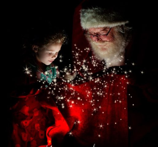 A sweet little girl takes a peek into Santa's magic toy bag at The Best Santa Experience in Mounds View, MN.