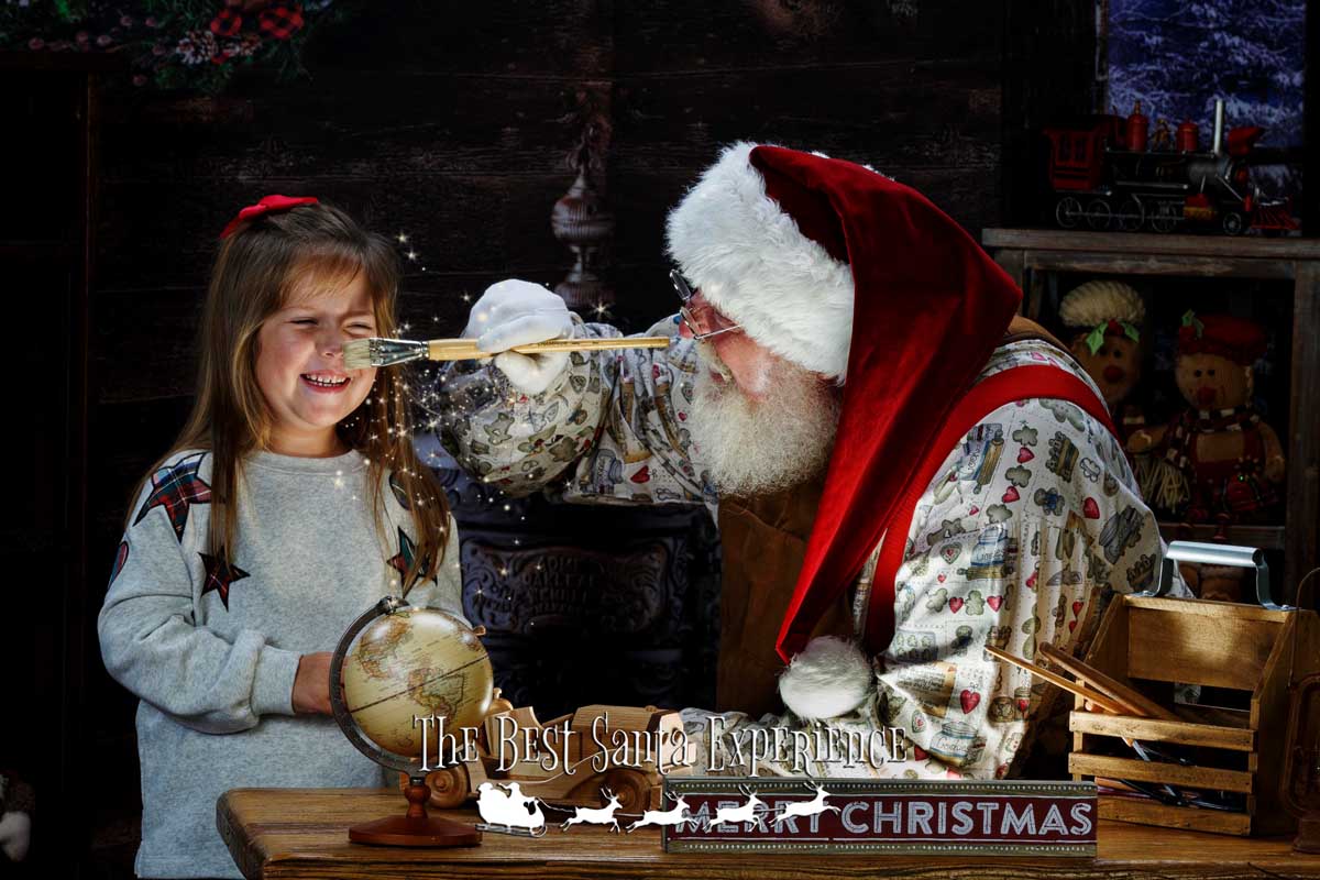 Santa puts a dab of "magic paint" on a young girl's nose at The Best Santa Experience.